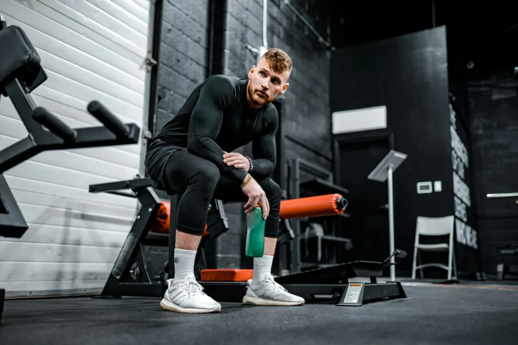 Man in the gym selecting a protein supplement pack for muscle building.