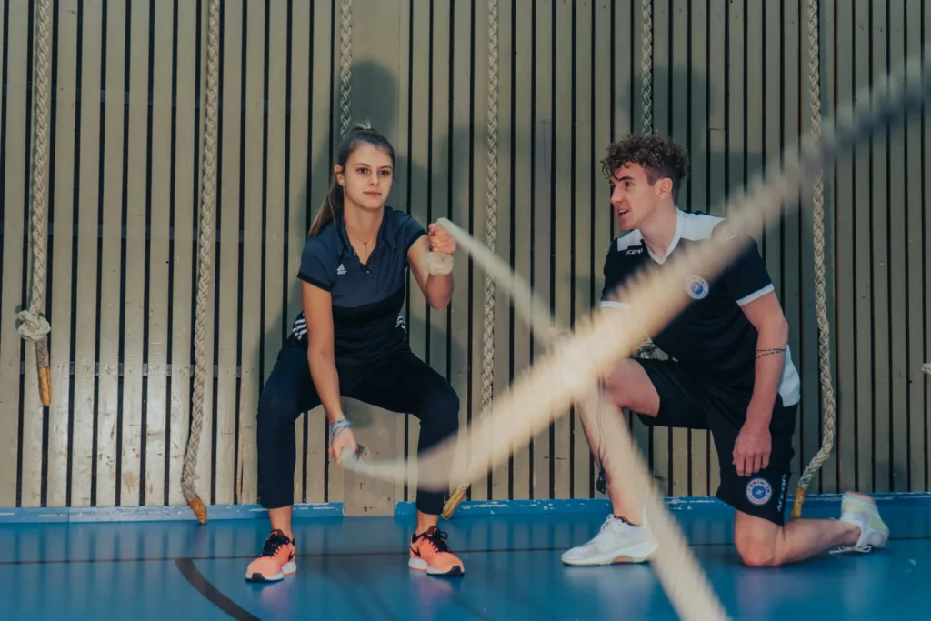 A boy and girl sorting Protean & Carbo fitness supplements, including protein powder and energy bars, for a balanced workout routine.